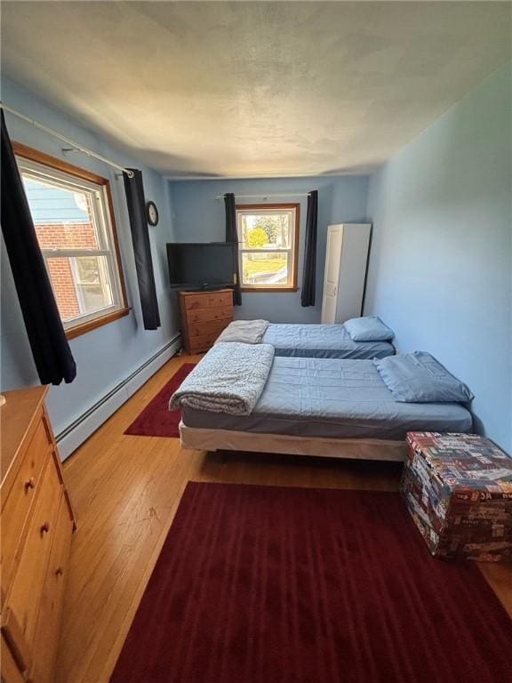 1001 W Broad St, Horseheads, NY 14845 - bedroom with a baseboard radiator, wood finished floors, and multiple windows