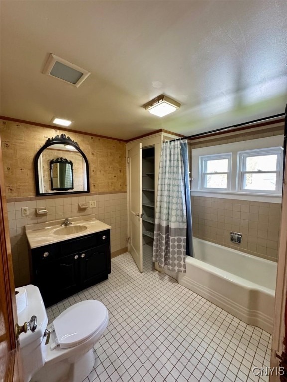 full bathroom with vanity, shower / bath combination with curtain, toilet, tile walls, and tile patterned floors