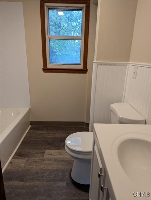 134 Malden Rd, Salina, NY 13211 - full bathroom with wood finished floors, a wainscoted wall, vanity, toilet, and a tub to relax in