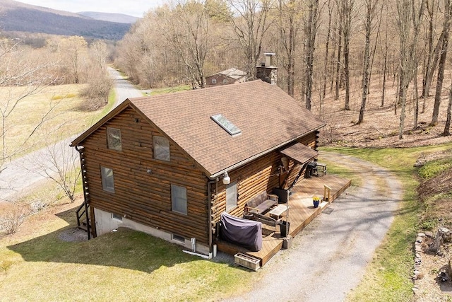851 Lower Meeker Hollow Rd, Roxbury, NY 12474 - view of home's exterior with a deck with mountain view, a chimney, a shingled roof, log exterior, and driveway
