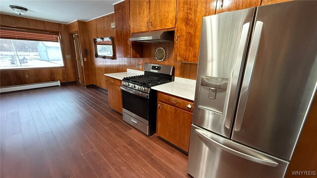 3319 Riverside Dr, Scio, NY 14895 - kitchen with baseboard heating, light countertops, under cabinet range hood, brown cabinets, and stainless steel appliances