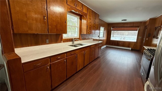 3319 Riverside Dr, Scio, NY 14895 - kitchen featuring dark wood-style flooring, gas range, light countertops, a baseboard heating unit, and a sink