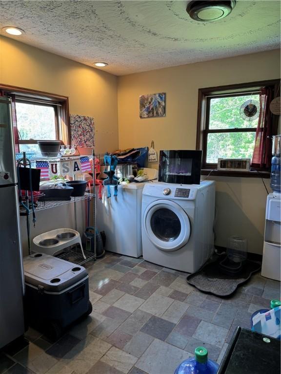 clothes washing area featuring washer / dryer, recessed lighting, laundry area, and stone finish flooring