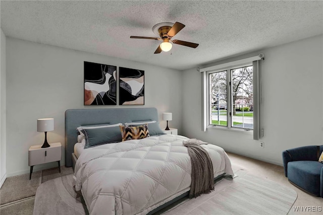 carpeted bedroom featuring baseboards, a textured ceiling, and ceiling fan