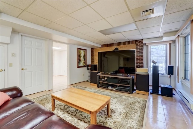 living room featuring baseboard heating, visible vents, a paneled ceiling, and tile patterned flooring