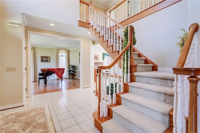 staircase featuring baseboards, tile patterned flooring, ornamental molding, and recessed lighting