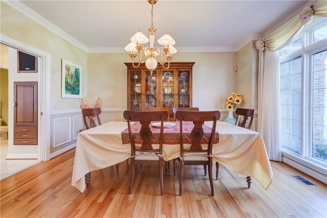 dining area with plenty of natural light, visible vents, light wood-style flooring, and a notable chandelier