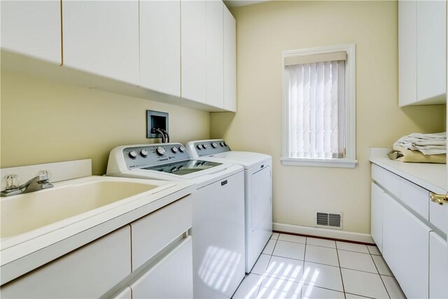 laundry room with visible vents, cabinet space, baseboards, light tile patterned flooring, and washer and dryer
