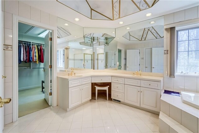 bathroom featuring double vanity, a sink, recessed lighting, and a shower stall