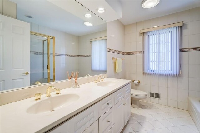 full bathroom featuring an enclosed shower, tile patterned floors, visible vents, and a sink