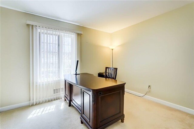 office space with baseboards and light carpet