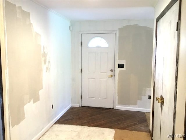 foyer featuring crown molding, baseboards, and wood-type flooring