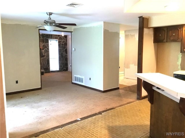 interior space with a ceiling fan, baseboards, and visible vents