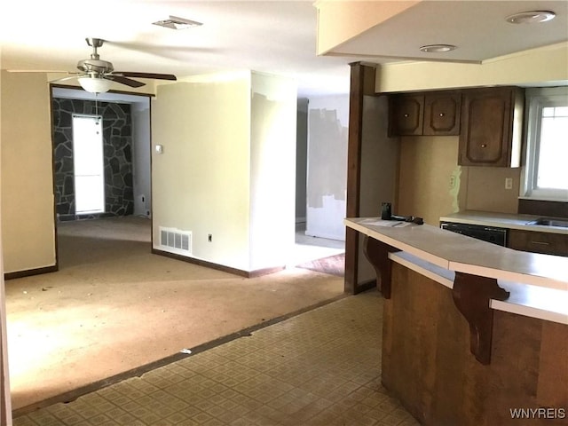 kitchen featuring ceiling fan, dark brown cabinetry, visible vents, light countertops, and baseboards