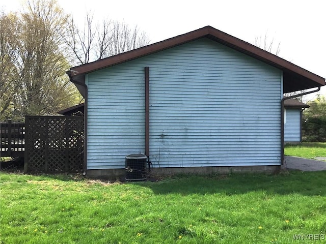 view of home's exterior with a lawn and central AC unit