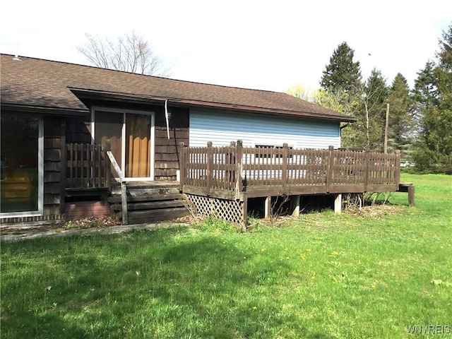 back of property featuring a lawn, a shingled roof, and a deck