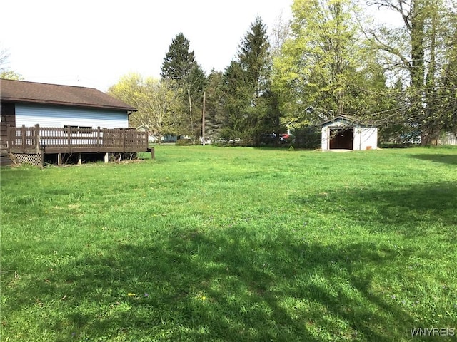 view of yard featuring a storage shed, an outbuilding, and a wooden deck