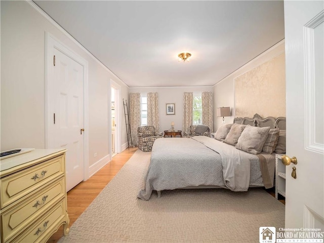 bedroom featuring crown molding and light wood-style flooring