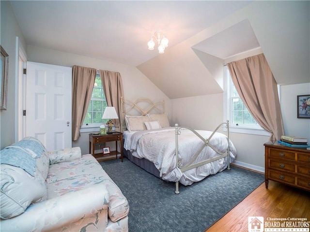 bedroom with baseboards, vaulted ceiling, and hardwood / wood-style flooring