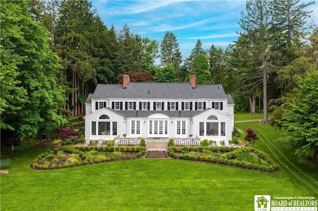 rear view of house featuring a yard, french doors, and a chimney