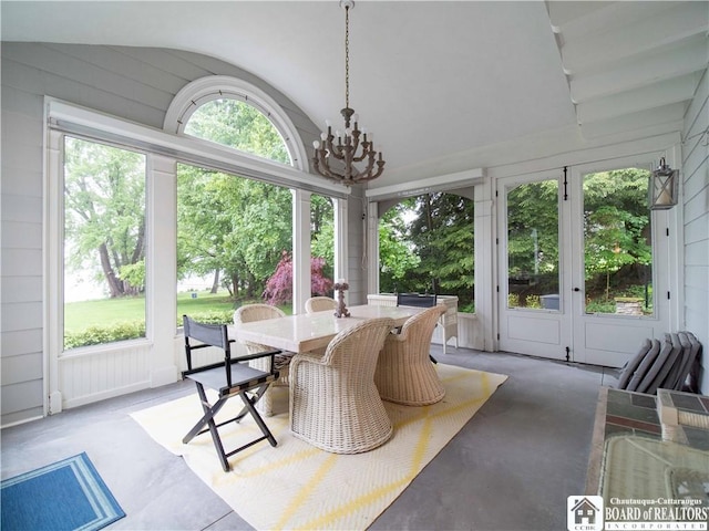 sunroom / solarium with outdoor dining area, a notable chandelier, and french doors
