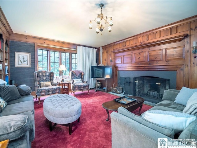 carpeted living room featuring an inviting chandelier, ornamental molding, a fireplace, and wooden walls
