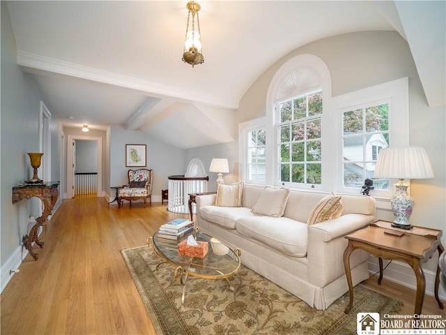 living room with baseboards, lofted ceiling with beams, and light wood-style flooring