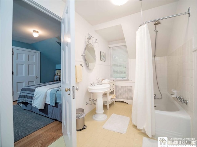 full bathroom featuring connected bathroom, wood finished floors, and shower / tub combo