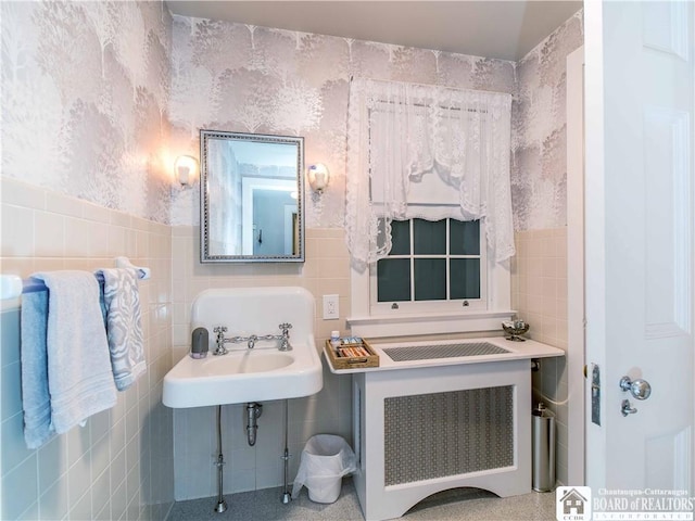 bathroom with wallpapered walls, tile walls, wainscoting, and radiator heating unit