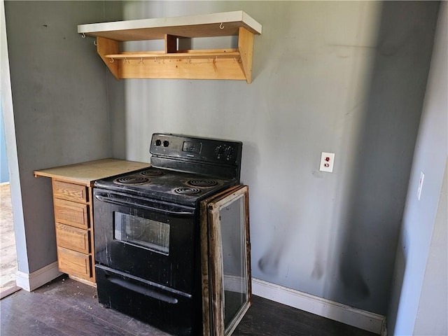 kitchen with dark wood-style flooring, baseboards, and black electric range