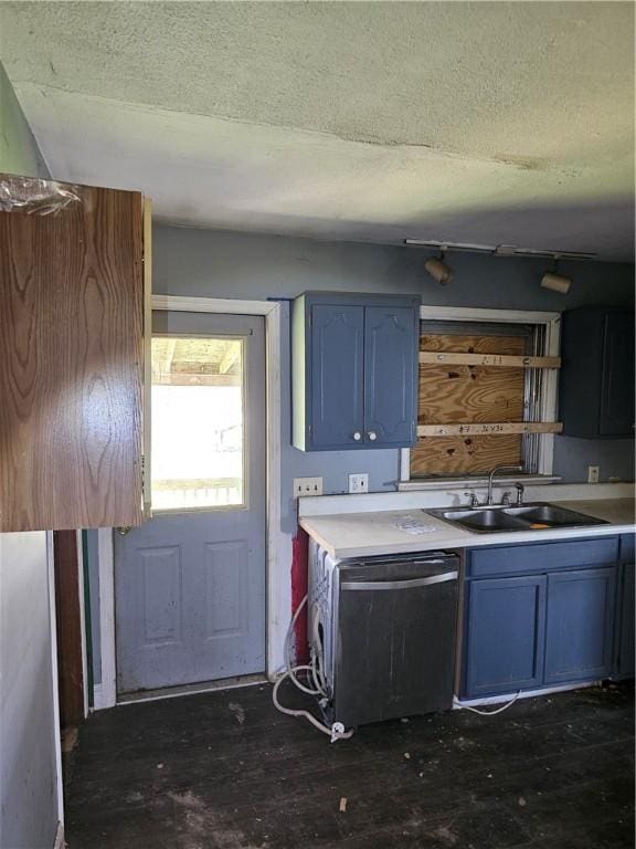 kitchen featuring blue cabinetry, a textured ceiling, a sink, light countertops, and dishwashing machine