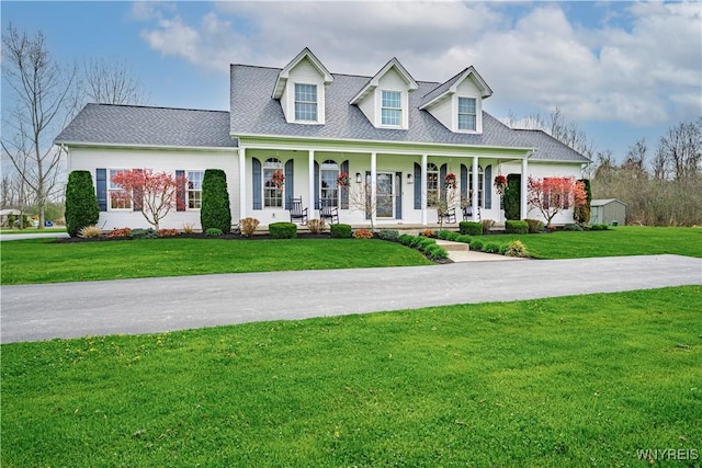 2575 Fuller Rd, Newfane, NY 14028 - cape cod house featuring roof with shingles, covered porch, and a front yard