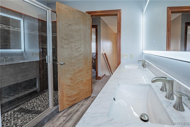 2575 Fuller Rd, Newfane, NY 14028 - bathroom with wood finished floors, double vanity, a sink, and a stall shower