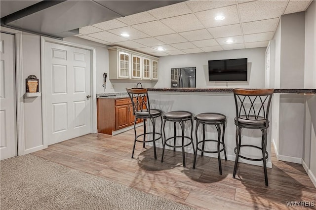 2575 Fuller Rd, Newfane, NY 14028 - kitchen with a peninsula, glass insert cabinets, a kitchen breakfast bar, recessed lighting, and stainless steel refrigerator with ice dispenser