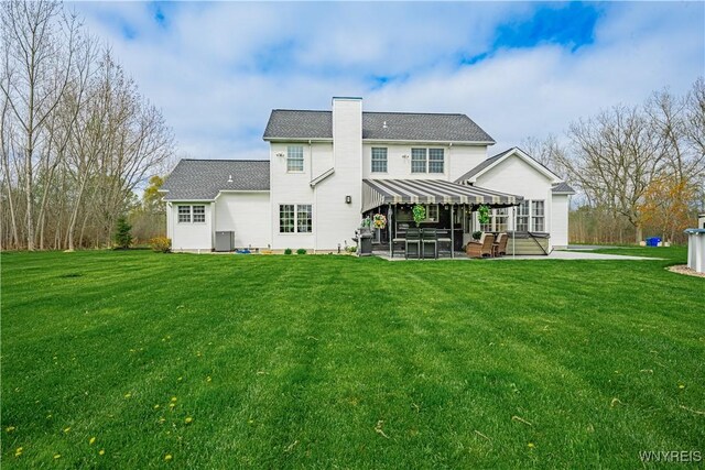 2575 Fuller Rd, Newfane, NY 14028 - back of property featuring a lawn, central AC unit, a chimney, and a patio area