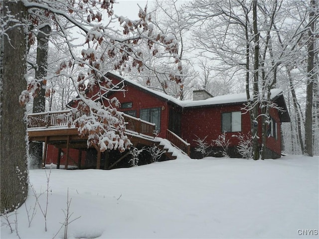 2321 Olanco Rd, Spafford, NY 13110 - view of front of house featuring a chimney, a wooden deck, and brick siding