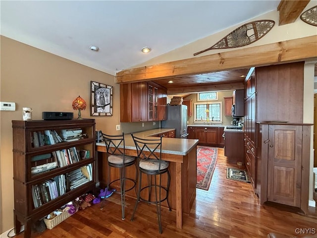 2321 Olanco Rd, Spafford, NY 13110 - kitchen with freestanding refrigerator, a peninsula, light wood finished floors, glass insert cabinets, and recessed lighting