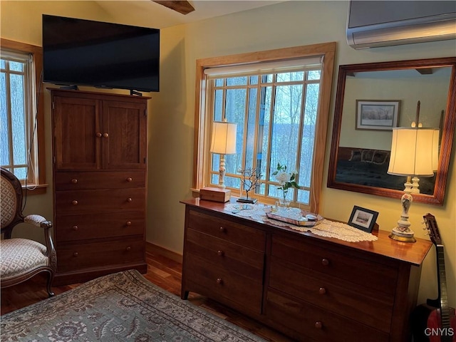 2321 Olanco Rd, Spafford, NY 13110 - bedroom featuring a wall unit AC, wood finished floors, and baseboards