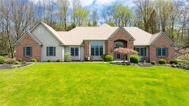 view of front of home with a front lawn and brick siding
