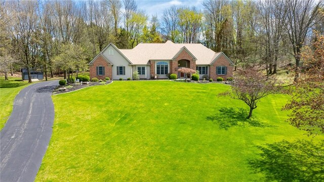single story home featuring brick siding and a front yard
