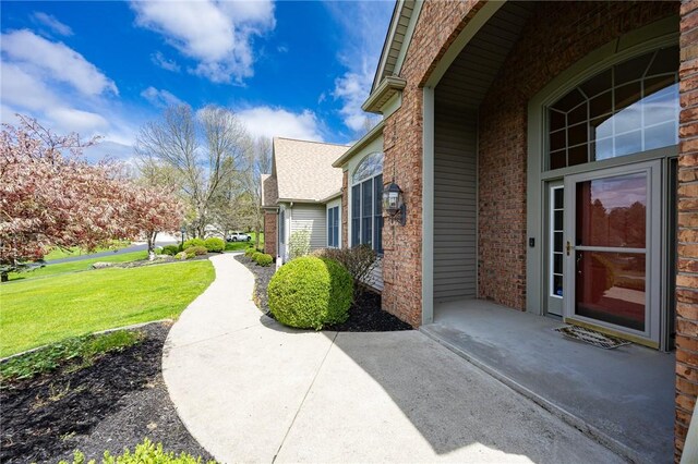 view of side of property with a lawn and brick siding