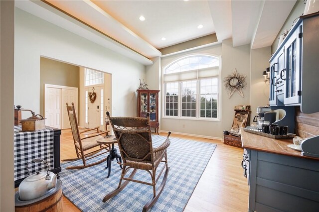 living area featuring recessed lighting, baseboards, plenty of natural light, and light wood finished floors