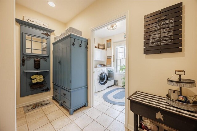 clothes washing area featuring cabinet space, independent washer and dryer, and light tile patterned floors