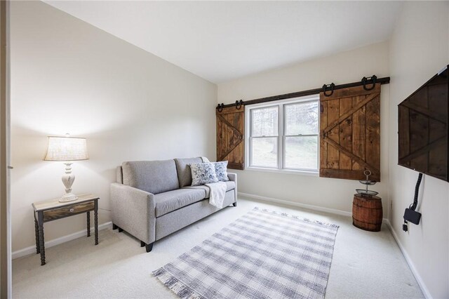 living room featuring baseboards, light colored carpet, and a barn door