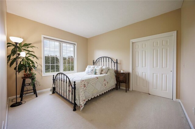 carpeted bedroom with baseboards and a closet