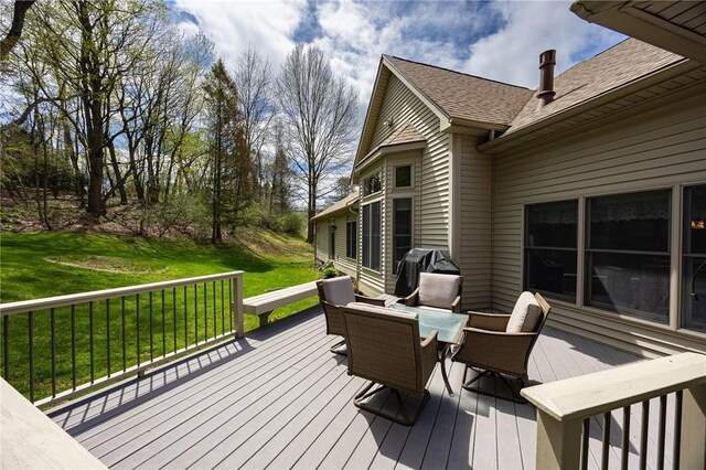wooden terrace featuring a yard and outdoor dining space