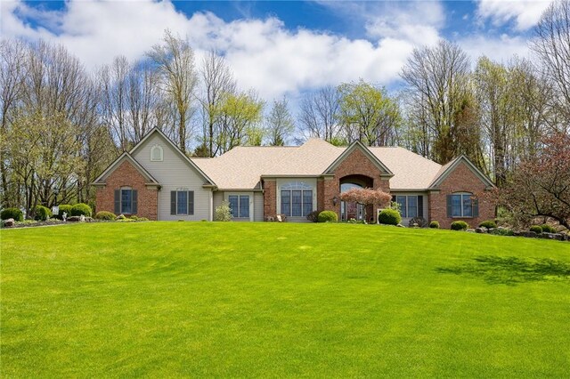 ranch-style home with brick siding and a front yard
