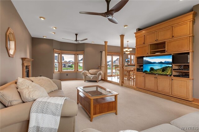 living room featuring recessed lighting, light colored carpet, and ceiling fan with notable chandelier