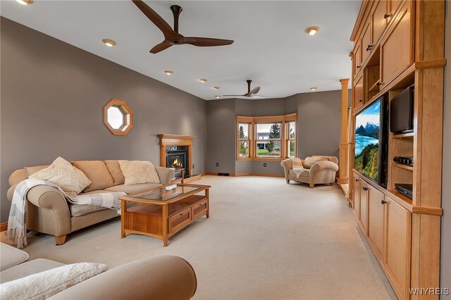 living room featuring ceiling fan, light carpet, a glass covered fireplace, recessed lighting, and baseboards