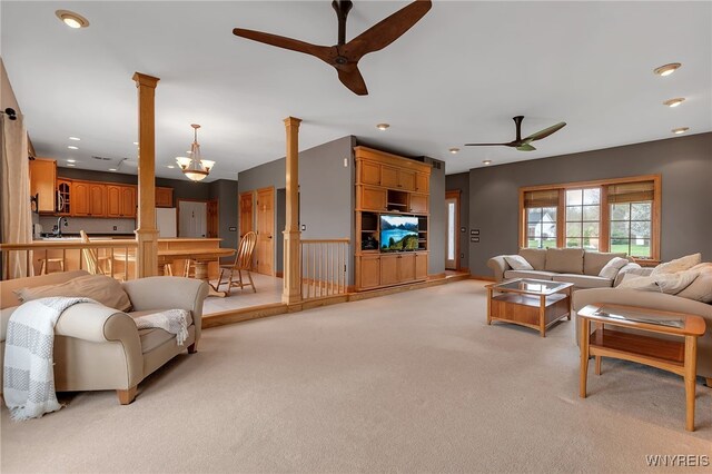 living room with light colored carpet, decorative columns, and ceiling fan